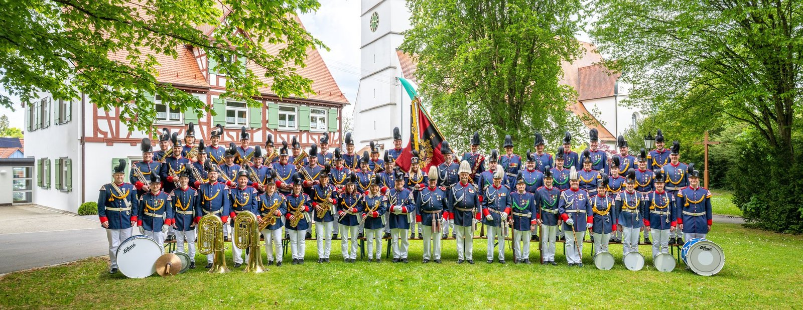 Gruppenbild der Historischen Bürgerwehr Mittelbiberach in Uniform vor Kirche und Pfarrhaus